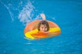 Summertime fun. Little kid swimming in pool. Kid in swimming pool relax and swim on inflatable ring. Summer vacation