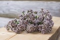 Beautiful closeup of summer smell with natural fresh oregano blossom bouquet on wooden bench with log house wall on background Royalty Free Stock Photo