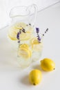 Summertime lemonade with lavender and lemon pieces in glasses and jar Royalty Free Stock Photo