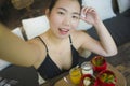 Summertime lifestyle portrait of young attractive and happy Asian Korean woman taking selfiei having healthy lunch with organic