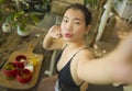 Summertime lifestyle portrait of young attractive and happy Asian Korean woman taking selfiei having healthy lunch with organic