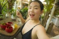 Summertime lifestyle portrait of young attractive and happy Asian Korean woman taking selfiei having healthy lunch with organic