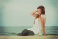 Redhead woman holding sun hat lying on beach Royalty Free Stock Photo