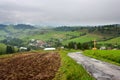 Summertime rural landscape - view at christian cross near road and the village Pucov, Slovakia