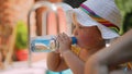 Summertime and vacation. Baby girl in swimsuit holding a bottle and drinks water