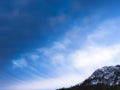 Dark clouds above a snowy rocky mountain top