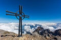Summit cross of Uri Rotstock mountain in Swiss alps, blue sky