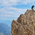 Summit high in the Alps, with an unrecognizable photographer on the edge