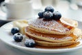 Sumptuous blueberry pancakes with a generous drizzle of golden honey for a delightful treat