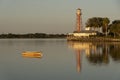 Sun glows at sundown over a small boat an lighthouse Sumter Landing, Florida.