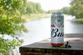 Budweiser Bud beer can on old wooden table outdoors at the river and green trees background Royalty Free Stock Photo