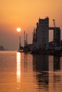 Sun and port structures create striking symmetrical water reflection scene Royalty Free Stock Photo