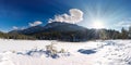 Sun beams shining in idyllic winter scenery