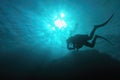 Sun beams shinning underwater and Scuba diver silhouette in the blue water Royalty Free Stock Photo