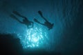Sun beams shinning underwater and Scuba divers silhouette in the blue water Royalty Free Stock Photo