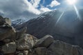 The sun beats down over the peak to some stones