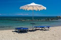 Sun beds and an umbrella on the beach, on the seashore Royalty Free Stock Photo