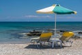 Sun beds and an umbrella on the beach, on the seashore Royalty Free Stock Photo