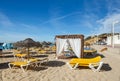 Sun beds, umbrellas and massage pavilion on the Salema beach, Algarve, Southern Portugal