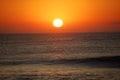 The sun begins to rise within the gray sea. Royalty Free Stock Photo