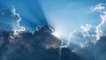 Sun behind dark clouds with sun rays on blue sky Royalty Free Stock Photo