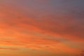 Sun below the horizon and clouds in the fiery dramatic orange sky at sunset or dawn backlit by the sun. Place for text and design Royalty Free Stock Photo