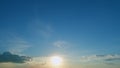 Sun below the horizon and clouds in the fiery dramatic sky. Cirrus clouds illuminated by sunbeams. Timelapse. Royalty Free Stock Photo