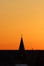 Sun below the horizon and the roof of the church with a cross on the background fiery dramatic orange sky at sunset or Royalty Free Stock Photo
