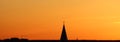 Sun below the horizon and the roof of the church with a cross on the background fiery dramatic orange sky at sunset or Royalty Free Stock Photo