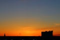 Sun below the horizon and television antenna in the background fiery dramatic orange sky at sunset or dawn backlit by Royalty Free Stock Photo