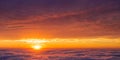 The sun bids its golden farewell, casting hues of pink and orange high above the clouds. Royalty Free Stock Photo