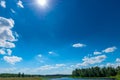 sun and blue sky over a picturesque river