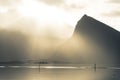 Sun breaking through clouds on a rainy day with dramatic sky, on lofoten islands norway, bridge in front of mountains in fog
