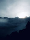 the sun breaking through the mist over mountains and building Royalty Free Stock Photo