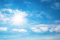 The sun with bright rays in the blue sky with white light clouds Royalty Free Stock Photo