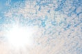 The sun with bright rays in the blue sky with white light clouds Royalty Free Stock Photo