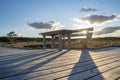 Sun casting low light during calm Sunset in summer over Wooden footpath Royalty Free Stock Photo