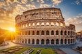 The sun casts its golden glow as it sets behind the iconic Colosseum in Rome, Italy, Ancient Roman colosseum under the setting sun Royalty Free Stock Photo