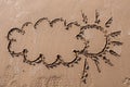 Sun and cloud drawing on beach sand Royalty Free Stock Photo