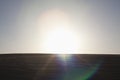 Sun coming down over a sand dune, no people, landscape, lens flare Royalty Free Stock Photo