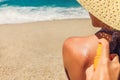 Sun cream protection. Man sprays sun cream on woman`s shoulder. Skin care concept. Healthy skin on vacation. Royalty Free Stock Photo