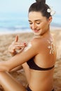 Sun Cream. Skin and Body Care. Woman in Bikini  Applying Sunscreen Solar on Tanned  Shoulder. Sun Protection lotion sunburn. Royalty Free Stock Photo