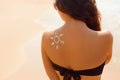 Sun cream. Suntan lotion beautiful woman applying on tanned shoulder in form of the sun. Sunscreen solar cream. Royalty Free Stock Photo