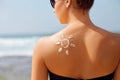 Sun cream. Suntan lotion beautiful woman applying on tanned shoulder in form of the sun. Sunscreen solar cream. Royalty Free Stock Photo