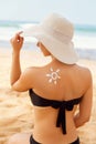 Sun cream. Suntan Lotion Beautiful Woman Applying on Tanned Shoulder In Form Of The Sun. Sunscreen Solar Cream. Royalty Free Stock Photo