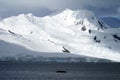 Sun dappled mountain in Antarctica with the ocean in the foreground