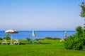 Sun debs on lawn on sea coast. Quiet place for relax by the sea waterfront Royalty Free Stock Photo