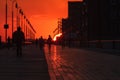 The sun disappearing beneath the horizon while the last golden light shines on a boardwalk. Long Beach NY