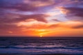 Sun disappears beneath horizon over ocean after spectacular sunset with vivid sky Royalty Free Stock Photo