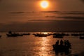 Sun Disk above Ocean with Boat and People Silhouettes at Sunset Royalty Free Stock Photo